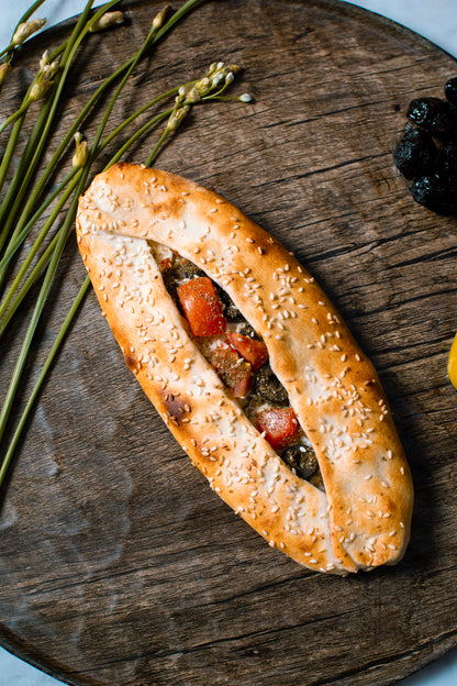 Sesame seed bread roll with fillings on a wooden board