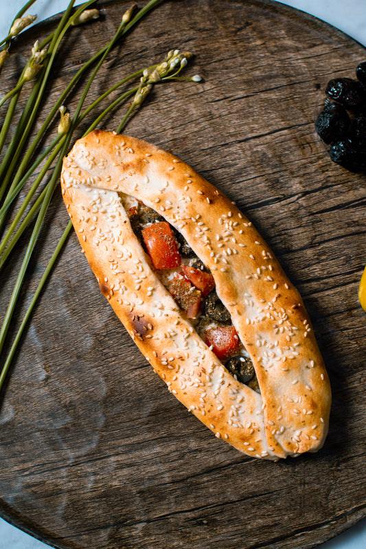 Sesame seed bread roll with fillings on a wooden board